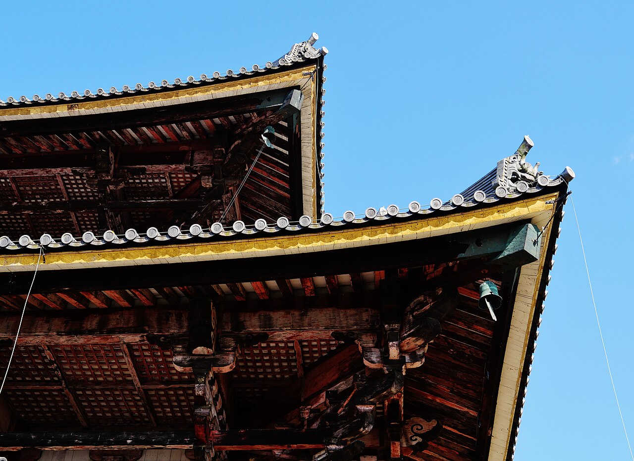 東大寺的木構屋簷，金色飾板在藍天下亮得晃眼