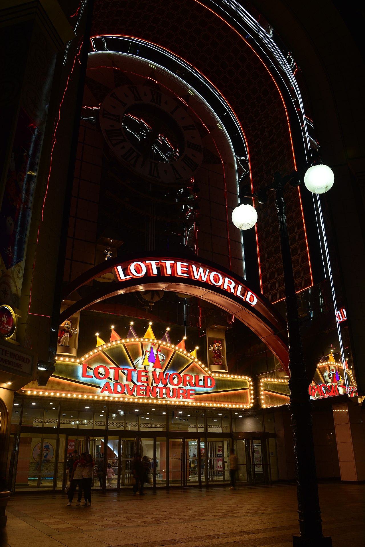 夜晚的樂天世界入口：拱門與 LOTTE WORLD 燈飾招牌
