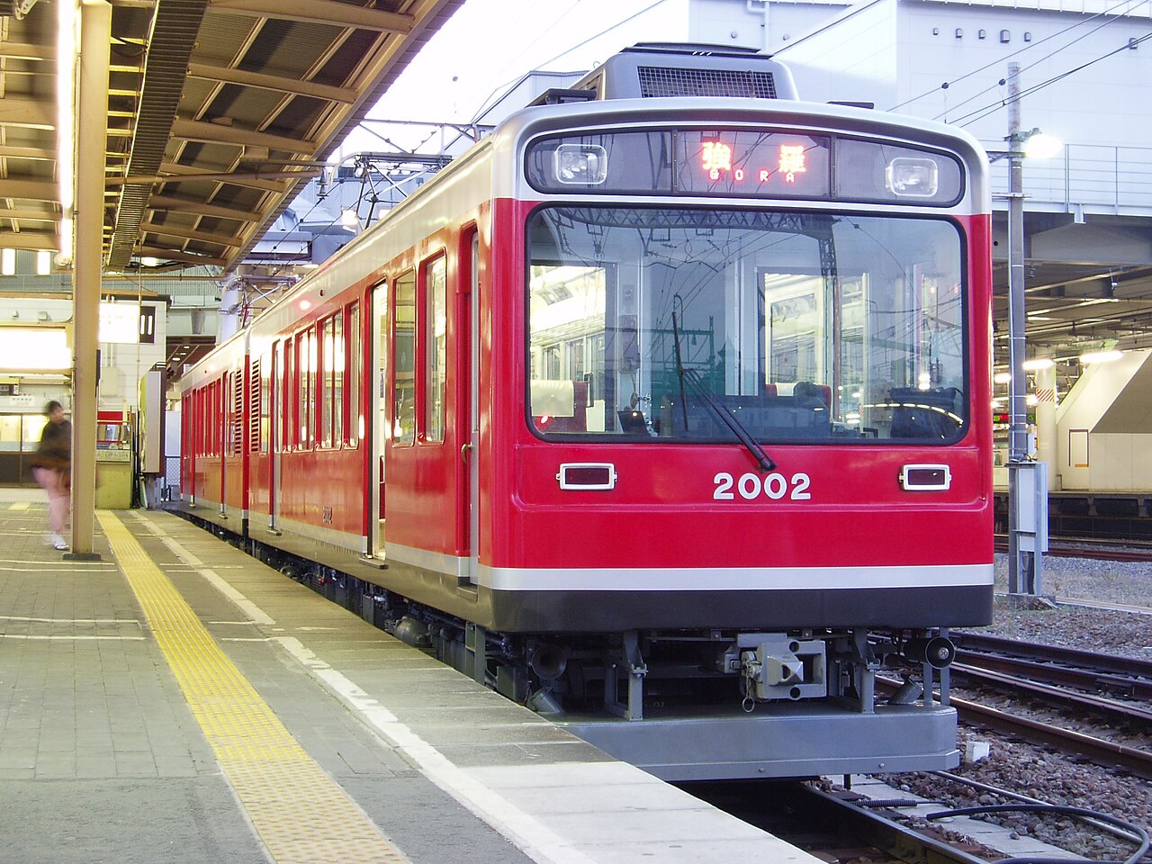 箱根登山電車停在月台上，車頭方向幕顯示終點「強羅 GORA」。從箱根湯本到強羅要做三次「之」字形折返才爬得上去（示意圖，非本人拍攝）