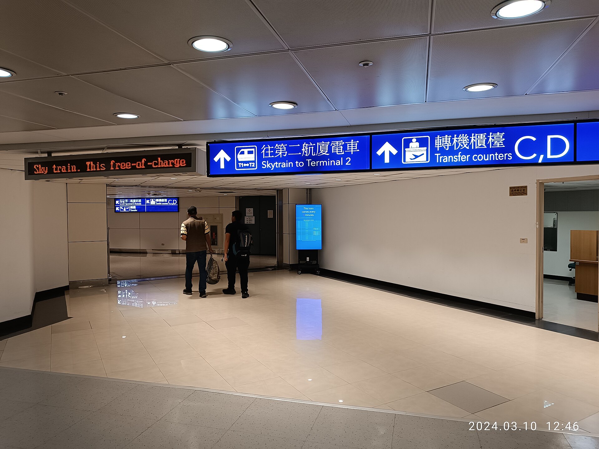 航廈裡往第二航廈電車的走道。預約接送的司機會在出口舉牌等你，出關後不用再找路
